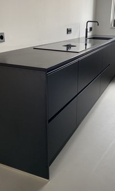 a black kitchen island with two faucets on it