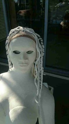 a white mannequin with long braids on it's head and eyes