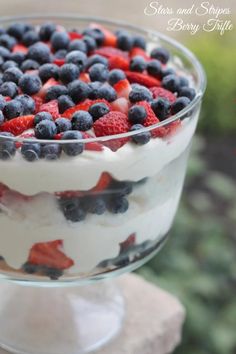 a trifle with strawberries, blueberries and raspberries on top in a glass dish