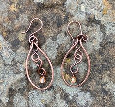 Hammered Copper with copper figure eights and flame colored crystal dangles. Come on handmade copper ear wires.Approximately 2" long from the top of the ear wire and 13/16" wideThese Earrings have been antiqued, polished and sealed.Sealed with Protectaclear ProtectaClear is a clear, protective coating that is tough enough to protect jewelry and is safe for wear against skin. ProtectaClear is practically invisible once applied and will seal and protect jewelry from tarnish, oxidation, and corrosi Colored Wire Jewelry, Bronze Wire Wrapped Copper Earrings, Bronze Wire Wrapped Teardrop Earrings, Copper Teardrop Dangle Earrings, Bronze Teardrop Copper Earrings, Bronze Copper Teardrop Earrings, Hand Forged Copper Wire Drop Earrings, Hand Forged Bronze Earrings With Copper Wire, Copper Earrings Handmade Ideas