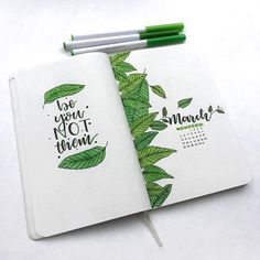 an open notebook with green leaves on it