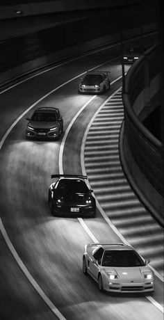 three cars are driving down the highway at night in this black and white photo,