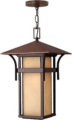 an outdoor hanging light fixture with a white glass shade on the front and side panels