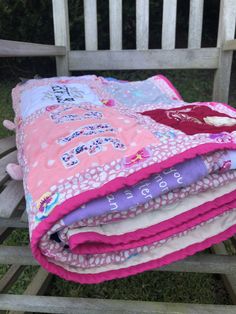 a stack of blankets sitting on top of a wooden bench