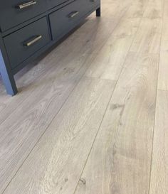 an image of a bathroom setting with wood flooring on the floor and vanity in the background