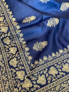 A stunning pure tussar silk saree in a lovely ink blue shade with all over machine embroidery in beige. The design has a very nice floral pattern with even borders on both sides and butis in the body. All over the saree is like this...simple but very elegant and beautiful. Fall, pico and tassels are done. Entire saree is finished with piping edging. Blouse is plain. Fabric is pure tussar silk. Its not rough, quite lightweight and has a lovely sheen Buti Embroidery Designs, Blue Tussar Silk Fabric With Resham Embroidery, Elegant Pashmina Traditional Wear With Chikankari Embroidery, Unstitched Blue Tussar Silk Embroidered Fabric, Blue Traditional Wear With Intricate Embroidery In Jamawar, Wedding Silk Pashmina Shawl With Embroidered Border, Blue Tussar Silk Fabric With Zari Embroidery, Blue Tussar Silk Embroidered Fabric For Wedding, Blue Embroidered Tussar Silk Saree