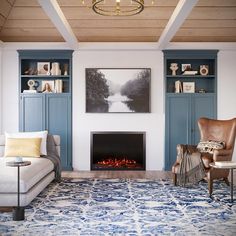 the living room is decorated in blue and white with a fire place on one wall