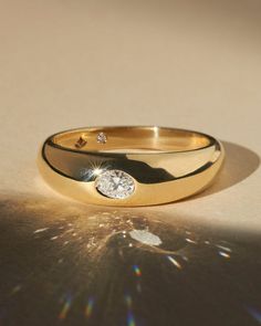 a diamond ring sitting on top of a table next to a sunraye background