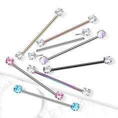 six different colored crystal hair pins on a white surface