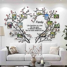 a living room filled with white furniture and lots of pictures on the wall above it