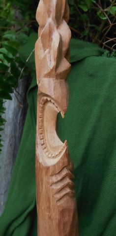 a carved wooden object sitting on top of a green cloth