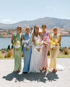 a group of women standing next to each other on top of a cement floor covered field