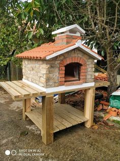 a small brick oven sitting on top of a wooden table