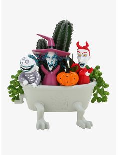 a bathtub filled with halloween decorations and fake cactuses on top of each other