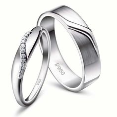 two white gold wedding rings with diamonds on each side and the word love written in cursive writing