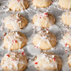 cookies with white icing and sprinkles are on a baking sheet, ready to be eaten