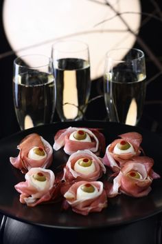 small appetizers are arranged on a black plate