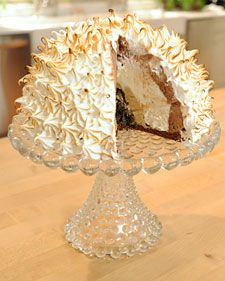 a cake sitting on top of a glass plate covered in frosting and icing