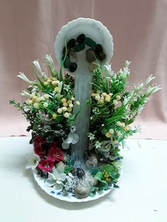 a water fountain with flowers and rocks in it