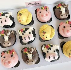 twelve cupcakes decorated with farm animals and flowers