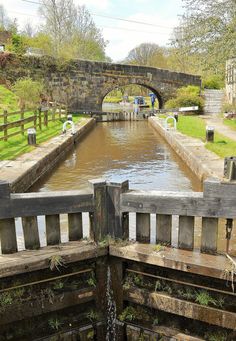 two wooden benches sitting on the side of a river