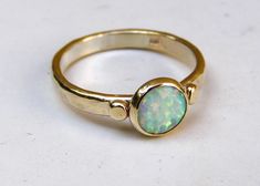 Recycled 14k yellow gold ring with Lovely white opal. MADE TO ORDER IN ANY SIZE A 14k yellow gold band holds a 8 mm bezel set with opal cabochon. The contrast between the opal and yellow is stunning. The ring has been tumbled for strength, and hand polished to give it a super shiny finish. This ring looks amazing when worn by itself or stacked with other rings. opal size: 8 mm Half wire 14k gold 3mm It will take me 1 week to make this order in your size. Fallow me on facebook for newest updates. Jewelry Vault, Engagement Ring Alternative, Opal Promise Ring, Etsy Engagement Rings, Rings Opal, Opal Ring Vintage, Blue Opal Ring, Alternative Engagement Ring, Opal Engagement Ring