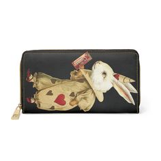 "This adorable valentines bunny wallet will add some charm to your wardrobe. Digitally enhanced from an antique valentines card and vintage chocolate label, it as colorful and timeless. For carrying around all your credit cards, cash, and driver's licenses look no further than this bunny wallet. Made with cruelty-free faux leather, this wallet comes packed with utility and style. Add your designs and create a daily staple that is unique and full of character. .: Material: Cruelty-free faux leather .: Durable high-quality nylon zip and alloy hardware .: Gold color thread stitching .: Pockets for cash, credit cards, coins, and checkbook .: One size: 7.87\" x 4.33\" (20cm x 11cm) Please be aware there may be slight flaws or color variations in my images due to the age and condition of the sou Vintage Black Wallet As A Gift, Novelty Rectangular Wallets As Gifts, Novelty Rectangular Wallet For Gift, Novelty Rectangular Wallet As Gift, Novelty Rectangular Wallet As A Gift, Retro Bifold Wallet As Gift, Retro Bifold Wallet As A Gift, Retro Wallets With Card Slots For Gift, Valentine's Day Wallets With Card Slots