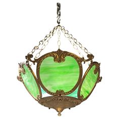 a green stained glass light hanging from a chain