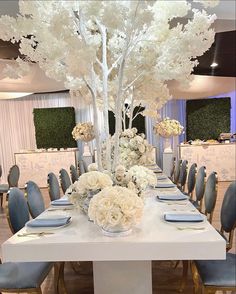 a white table with flowers and place settings