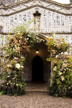 the entrance to an old building with flowers on it