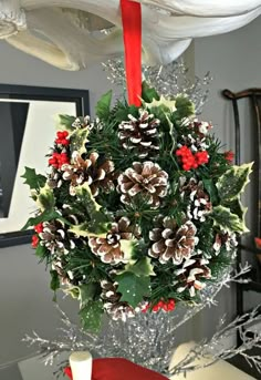 a bunch of pine cones hanging from a red ribbon