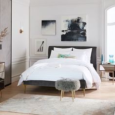 a bedroom with white walls and wooden floors