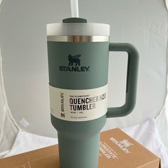 a travel mug sitting on top of a cardboard box