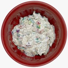 a red bowl filled with food on top of a white table