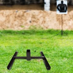 a black object is in the grass near a sign with a man's head on it