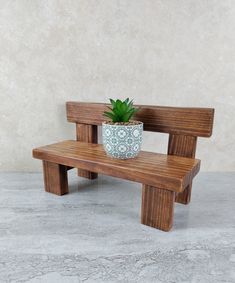 a wooden bench with a potted plant on it