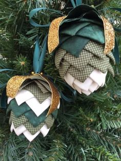 two green and white ornaments hanging from a christmas tree with gold glittered ribbons on them