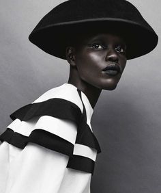 a woman wearing a black hat and white shirt is posing for a magazine cover photo