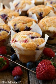 blueberry muffins cooling on a rack with fresh berries