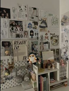 there are many pictures on the wall behind this bookcase, and in front of it is a bookshelf