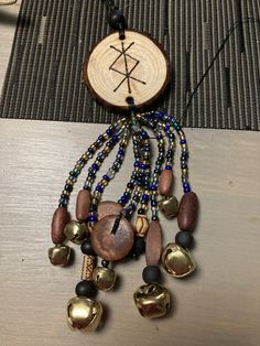 a wooden piece with beads and bells hanging from it