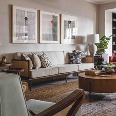 a living room filled with lots of furniture next to a large window and a painting on the wall