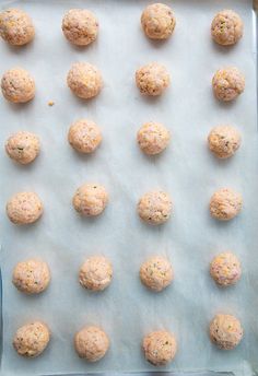 raw and uncooked meatballs on a baking sheet ready to be baked in the oven