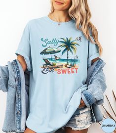 Discover our Vintage Salty but Sweet Comfort Colors shirt! This cute t-shirt features an eye-catching design with a retro graphic of a Tropical Beachy Scene. Made of 100% ring-spun ethically grown cotton, this shirt is super soft and comfortable. It has a relaxed fit which is made of a medium fabric that is preshrunk. Looks super cute with shorts or jeans and throw a cardigan on top for that cooler evening. Size up 1-3 sizes for an oversized beach coverup. Great gift idea for a Beach Lover! Come Cute Crew Neck T-shirt For Beach Season, Cute Relaxed Fit T-shirt For Beach Season, Casual Blue T-shirt For Beach Party, Beachy Crew Neck T-shirt With Funny Print, Cute Graphic Print T-shirt For Beach Season, Cute Beach T-shirt With Screen Print, Cute Pre-shrunk Tops For Vacation, Cute Short Sleeve T-shirt For Beach Season, Cute Graphic Print T-shirt For Vacation