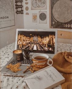 an open laptop computer sitting on top of a table next to a cup of coffee