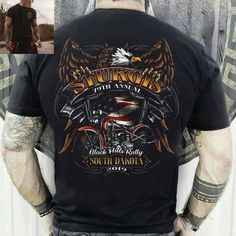 the back of a man wearing a black shirt with an eagle and motorcycle design on it