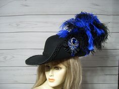 "Black Cavalier woolen hat with black braided trim, black and royal blue ostrich plumes, black cocarde with a sparkly jewel center. This hat is 22.5\" for the inside circumference but does have a built-in hat sizer. I'm sorry, I cannot make the inside circumference bigger. Check out my other cavalier and pirate hats in my etsy shop. I ship Priority mail. I ship many times a week. If you need your item quicker let me know your zip code and I can figure shipping rates for you. Please let me know if you have any questions I accept Paypal, credit cards and etsy gift cards   All sales are FINAL, no returns or exchanges please keep this in mind before purchasing. International buyers: Please know that you will be held responsible for any CUSTOMS FEES. Please check with you local post office, bef Black Hat For Carnival, Cavalier Hat, Musketeer Hat, Random Oc, Pirate Hat, Woolen Hat, Ren Fest, Pirate Hats, Black Braids