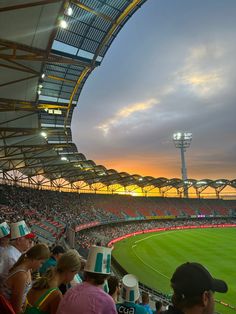 an empty baseball stadium filled with people at sunset