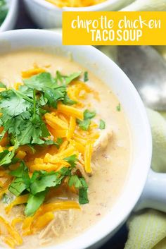 a white bowl filled with soup and topped with cilantro, cheese and green garnish