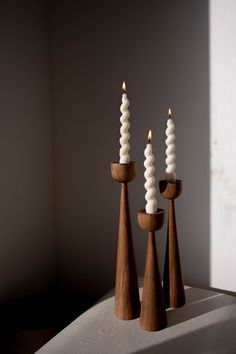 three candles sitting on top of a table next to each other